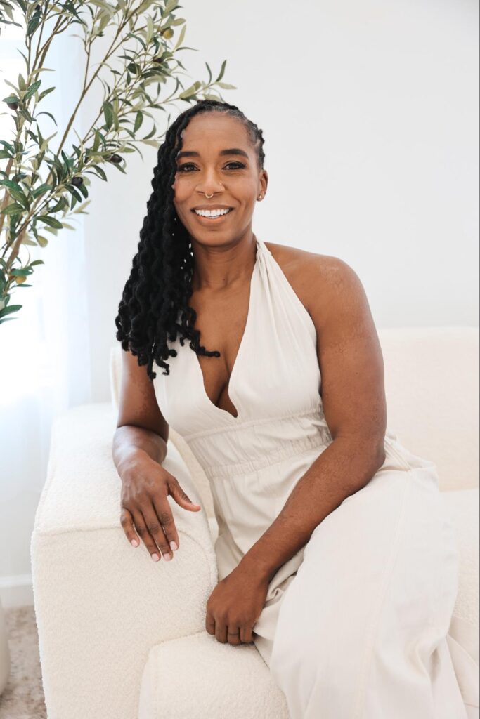 Dr. Hope L. Hayes sitting on a sofa, smiling warmly in a relaxed and welcoming posture