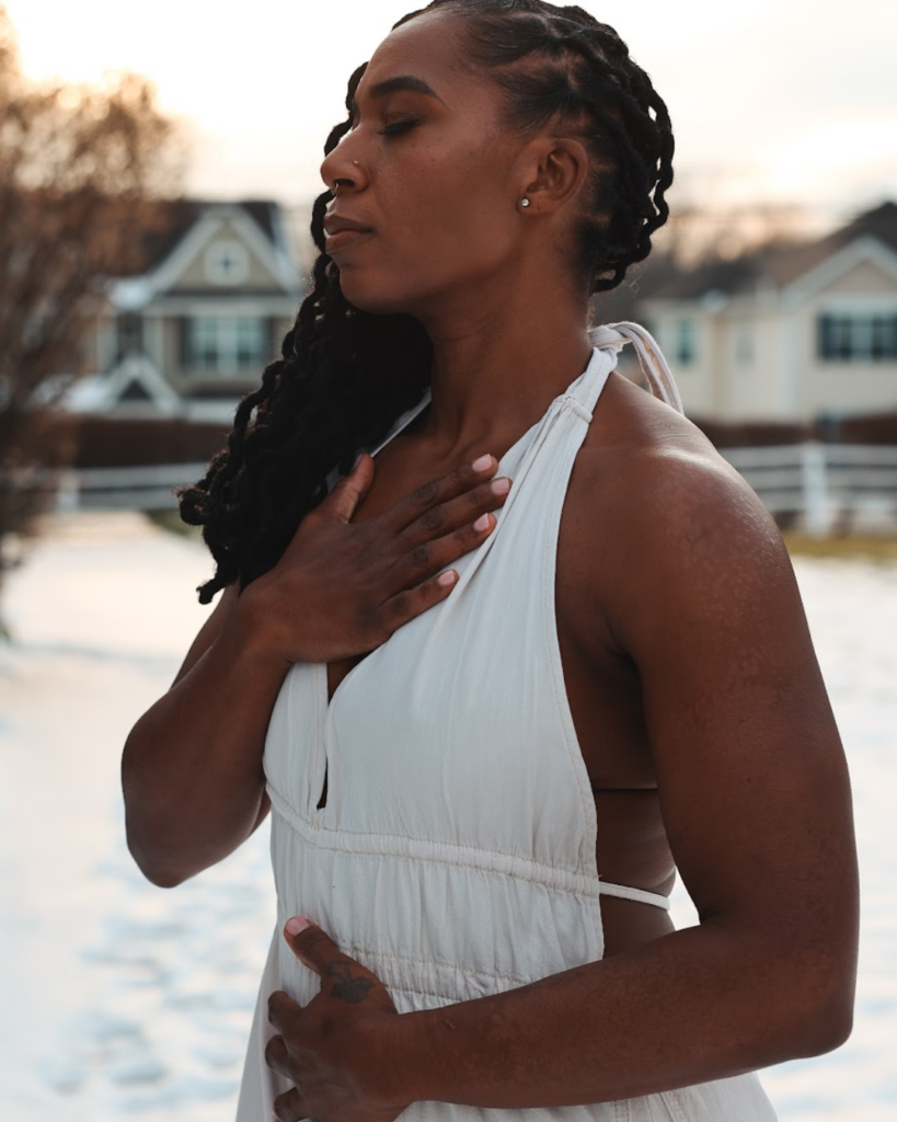 Dr. Hope L. Hayes illustrating mind-body connection in pelvic floor therapy with hands on chest and lower abdomen
